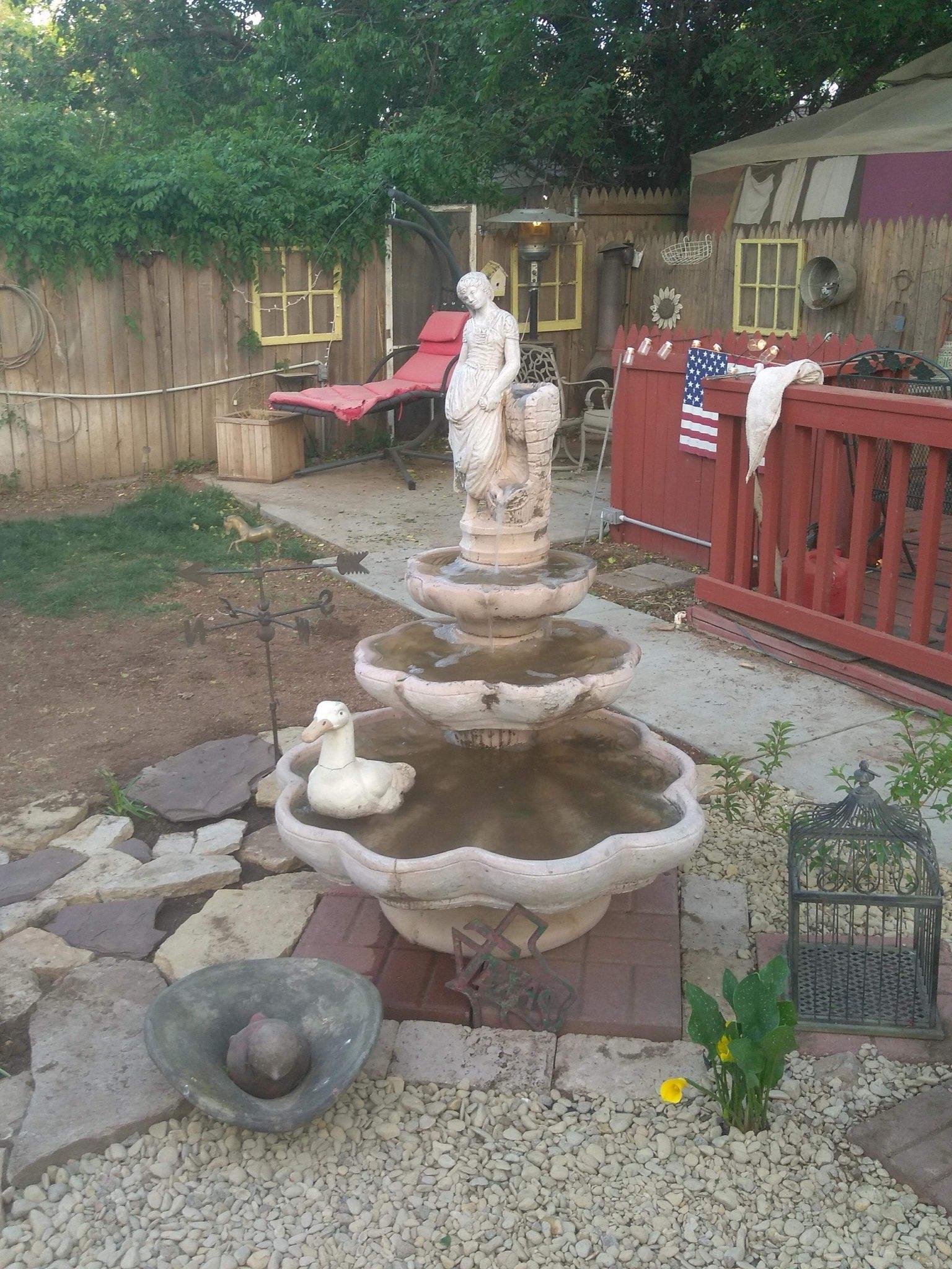 Backyard landscaping with a decorative fountain