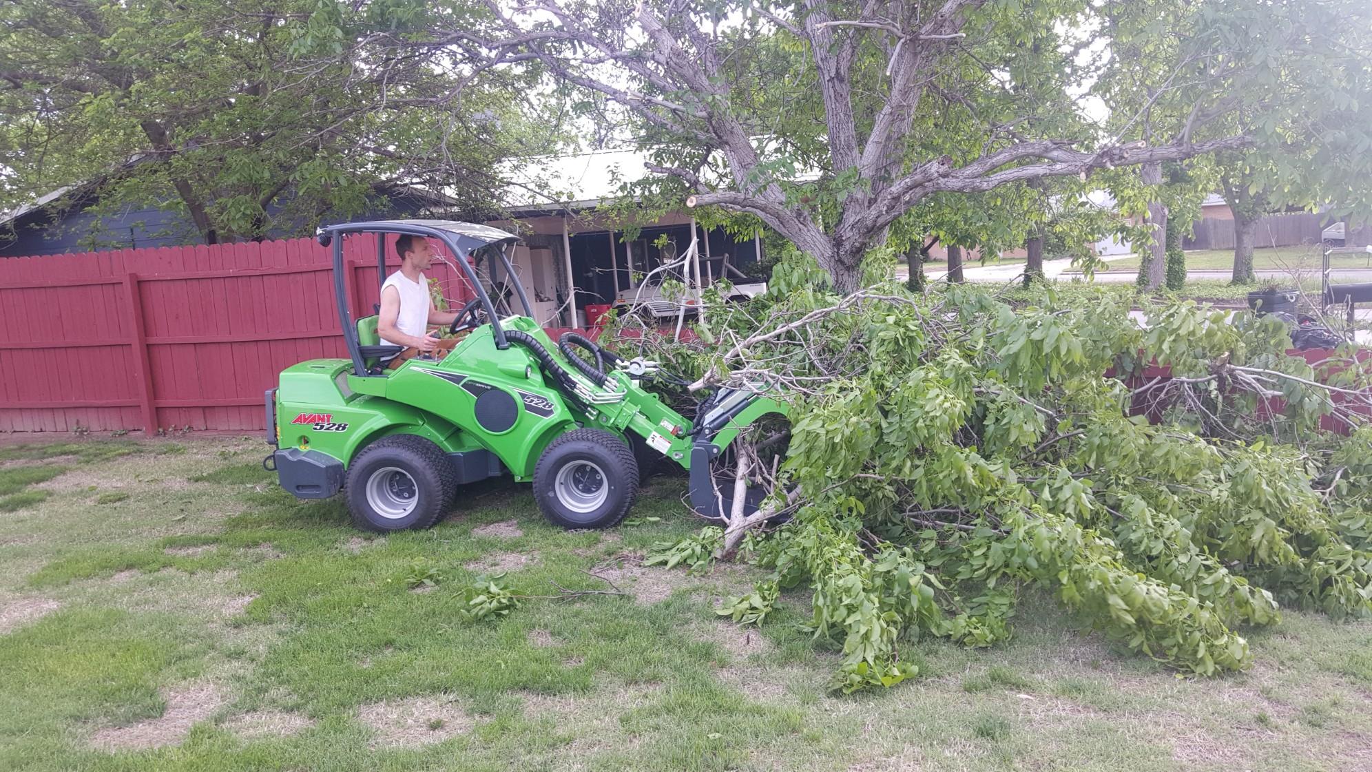 Using a mini loader to move large tree branches